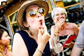 During cocktail hour at Domaine de Massoulac, a well-dressed guest enjoys the festivities, mingling amidst the gardens and joining in the cheerful atmosphere.